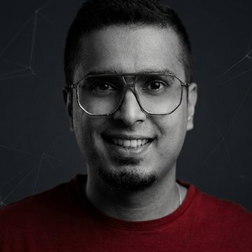 Karthik Rajan portrait faded into the right edge of the dark hero